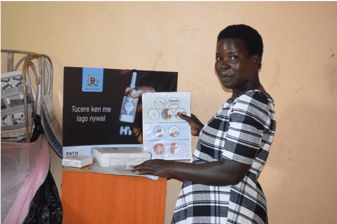 Eveline Awio shows off the materials she uses in her FP corner to talk to women in her community about family planning.