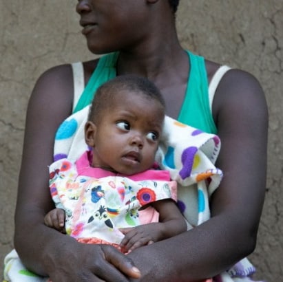 A mother holds her baby. Source: EGPAF Kenya