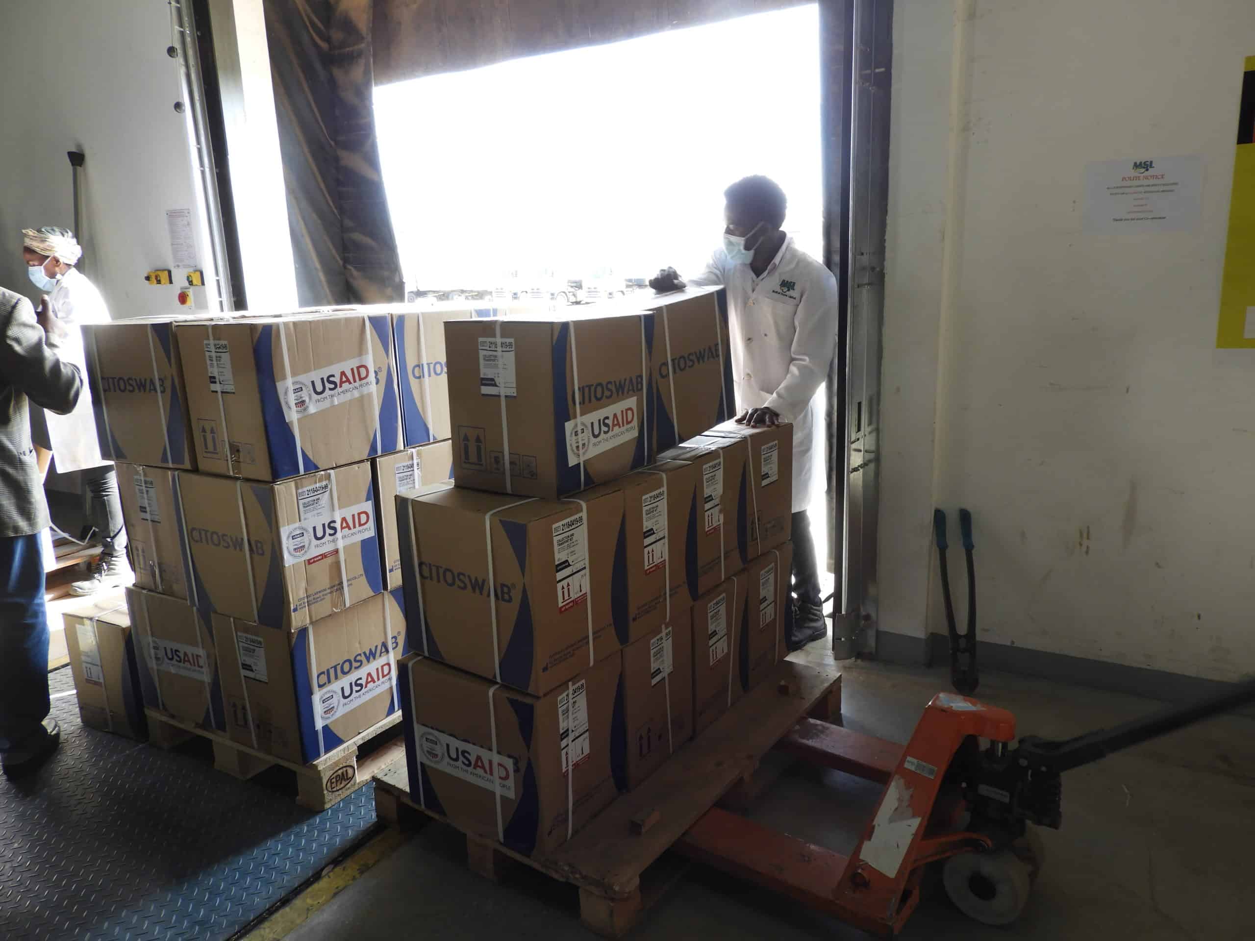 JSI staff load boxes of essential items onto a truck for COVID-19 response in Zambia.