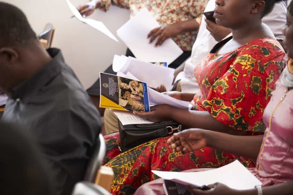 A Violence against Women and Children Committee member holds the National Plan of Action to End Violence against Women and Children in hand as a reference during a recent committee meeting in the Geita region of Tanzania. / Erick Gibson for JSI Research & Training Institute, Inc.