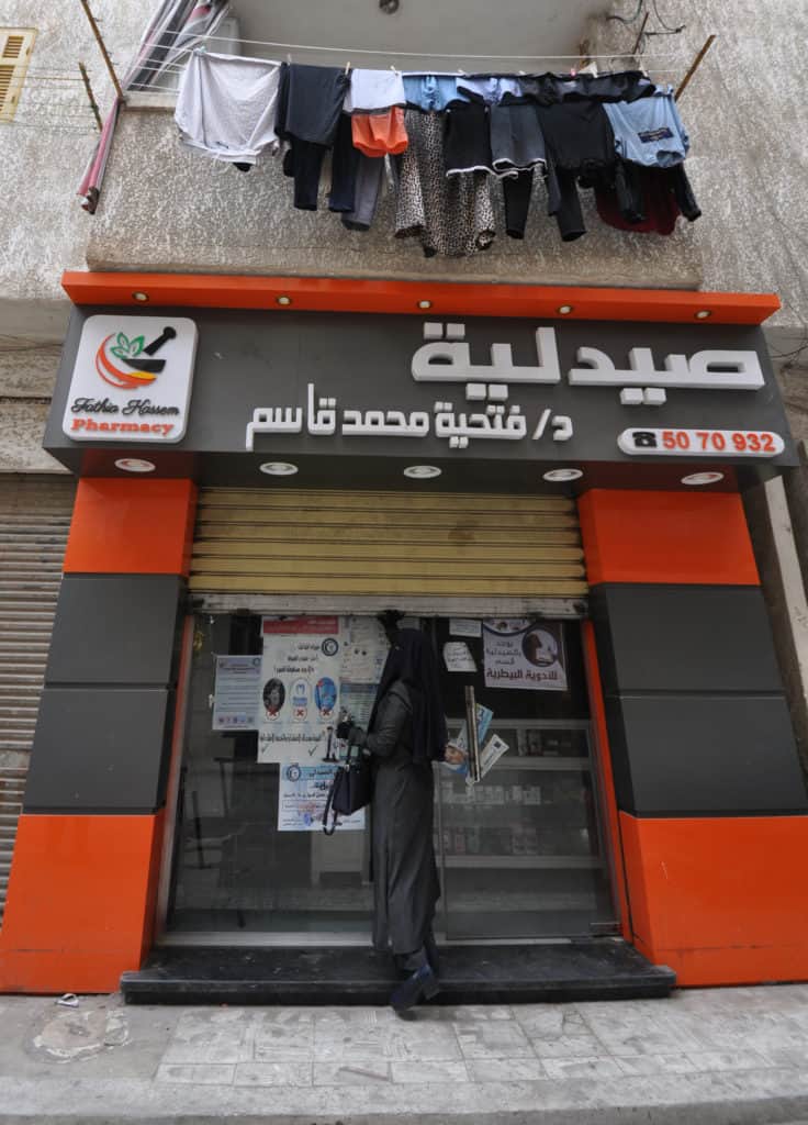 Dr. Fathia stands in front of her pharmacy in Egypt.