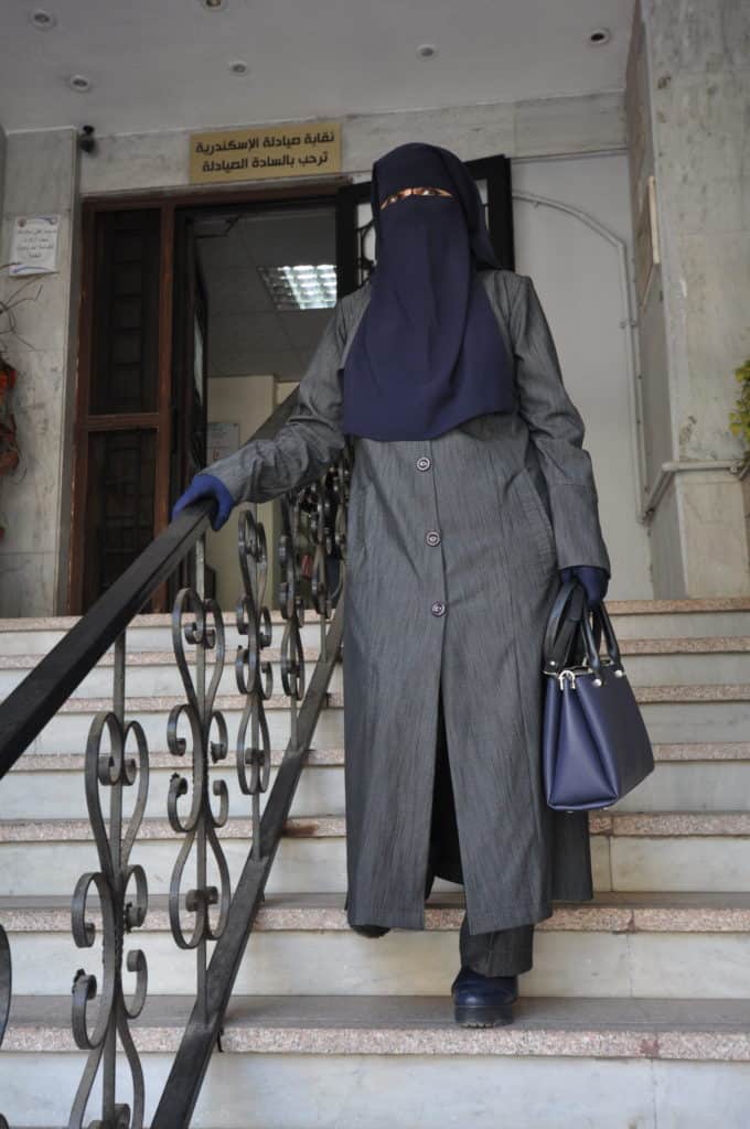 Dr. Fathia stands on the steps in front of the local syndicate office.