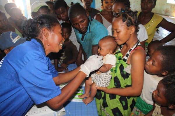 A female health worker administers a vaccine to a child in Madagascar.