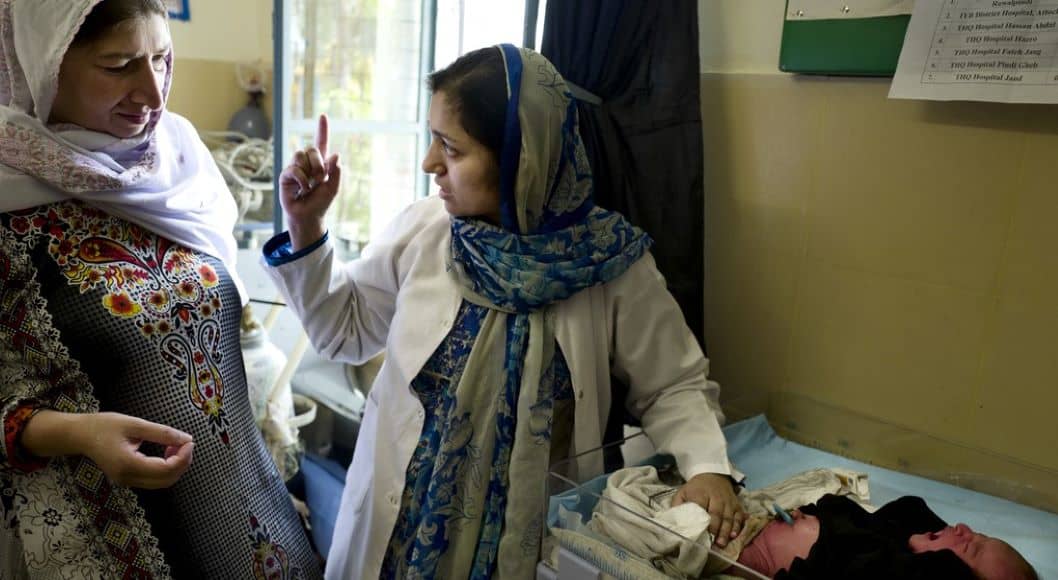 A Pakistani health care worker attends to a baby in a health care facility