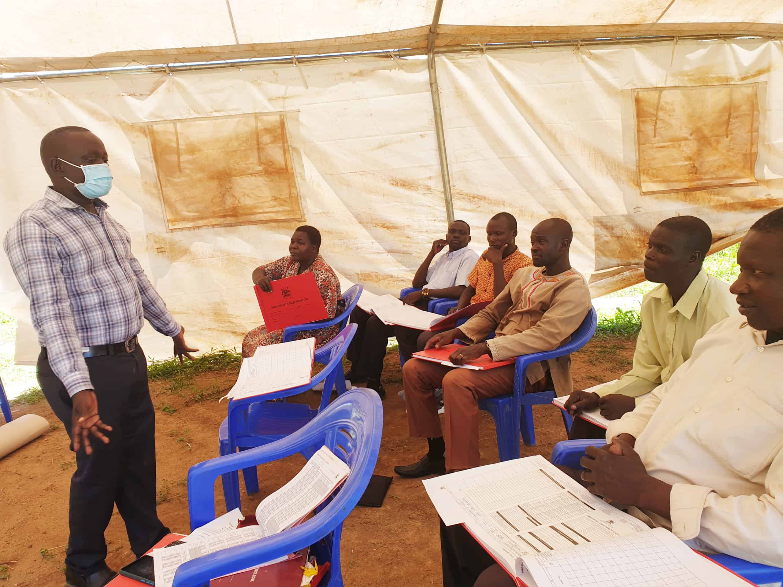 David (R) joins other vaccinators in a training on filling child registers that are used to make follow-ups on vaccinations for children