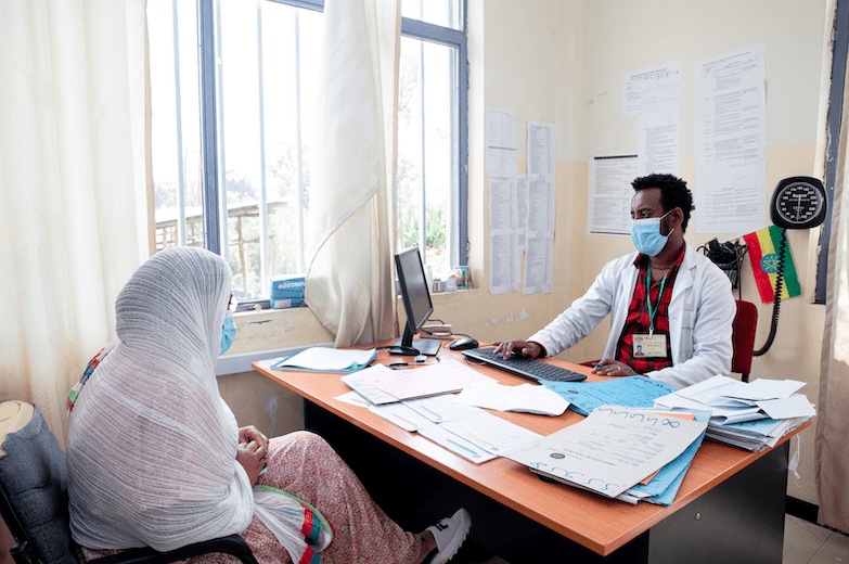 A health worker in Ethiopia records a patient's data in an electronic community health information system on a computer.