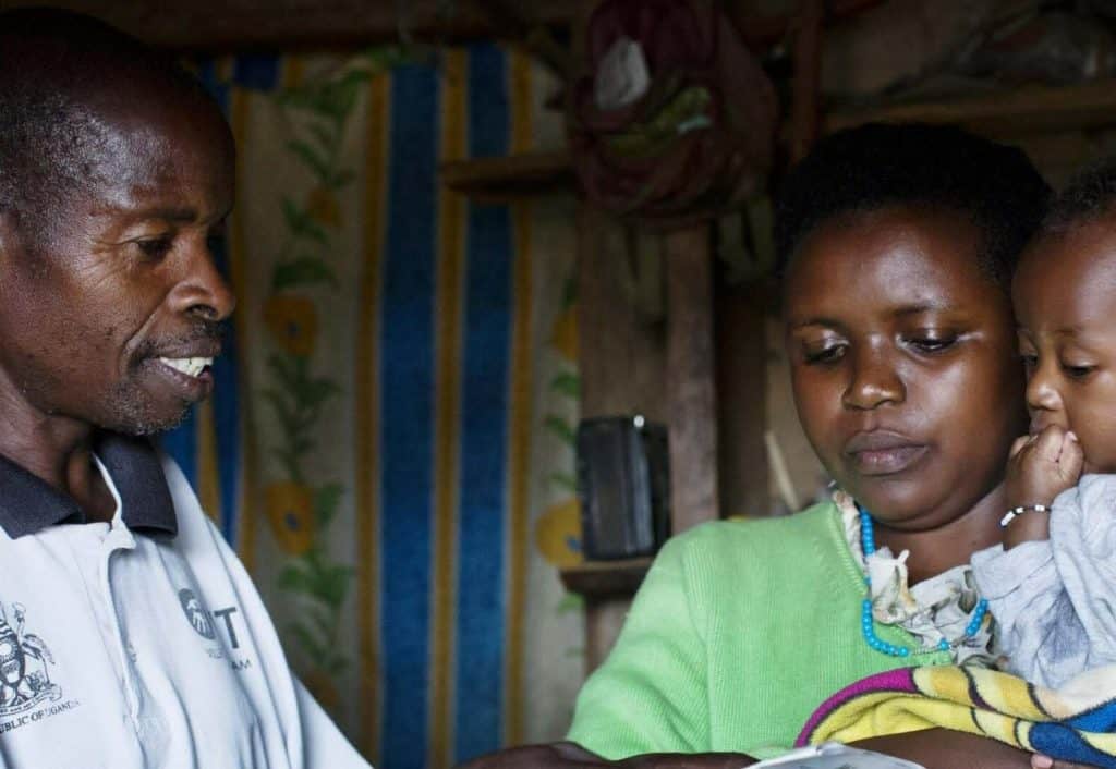 A MOMENTUM supported health care worker assists a mother and her young child.