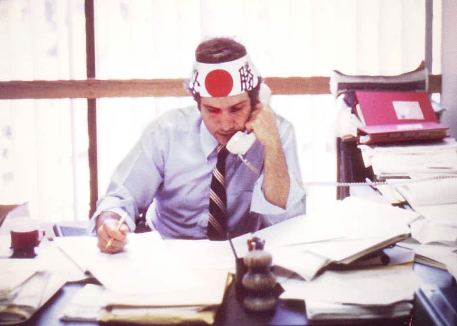 Joel Lamstein wears a samurai headband while on the phone in his office.