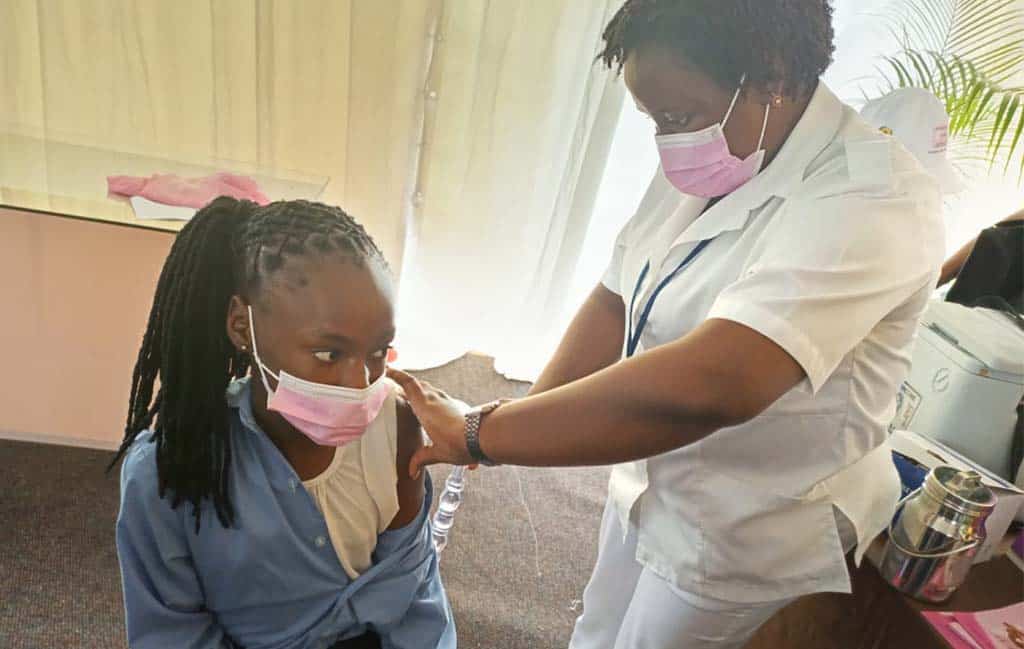 A healthcare worker provides an HPV vaccine to a young girl.