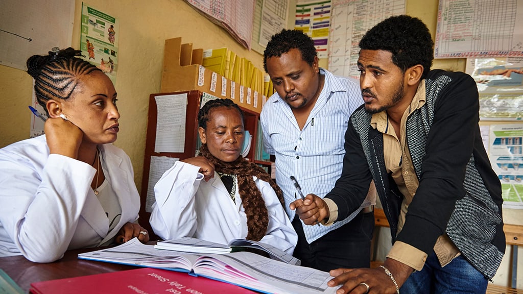While Tesfu Negasa (right), Zonal HMIS Office, discusses Tally Sheet and it's importance to HMIS with health team members at a Chancho Buba Health Post in Oromia Region. Ethiopia.