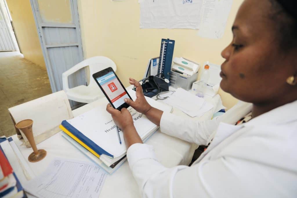 A nurse in the Maternal and Child Healthcare Department of the Chorora Health Center in EThiopia is using the eCHIS application on a small table.
