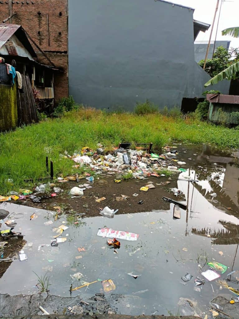 garbage on roadways in makassar after a recent flood