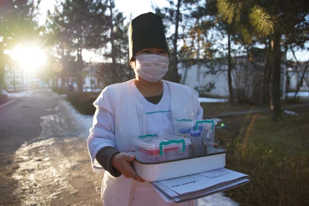 Nurzhamal Mamytkazieva, a nurse, carries supplies.