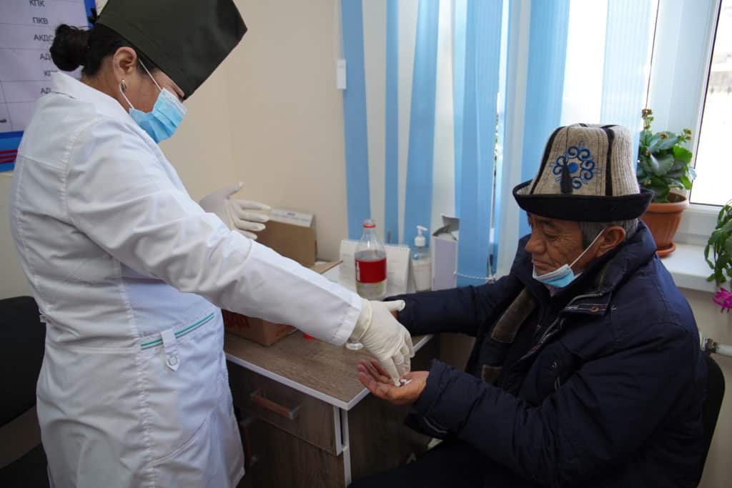 Nurzhamal Mamytkazieva, a nurse, gives TB medicine to Ishen Koldoev, a patient with TB.