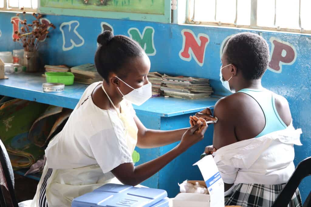 14-year-old school-pupil Mercy receives her second dose of the COVID-19 vaccine at school in Kabwe