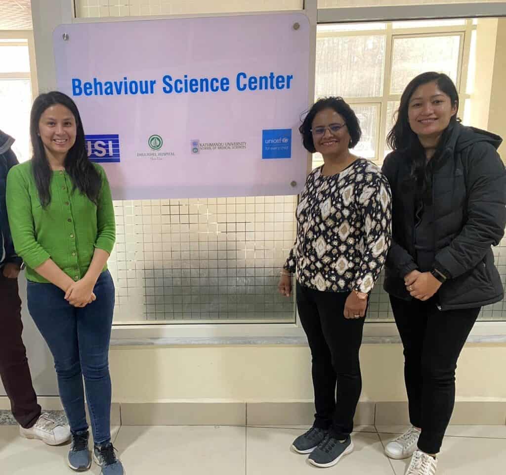 Three women stand in front of a sign that reads Behavior Science Center