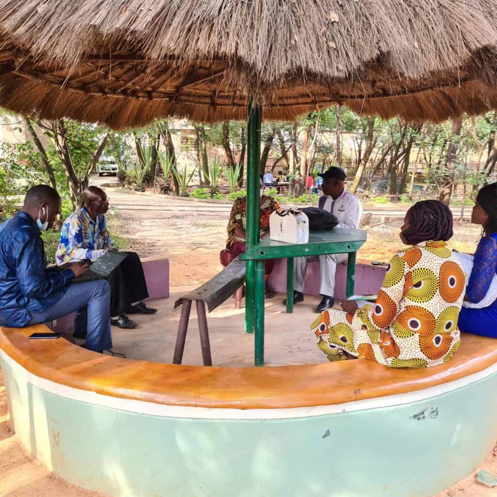 People engaged in discussions at DRC Haut-Katanga Kenya Co-Creation Workshop in an outdoor seating space.