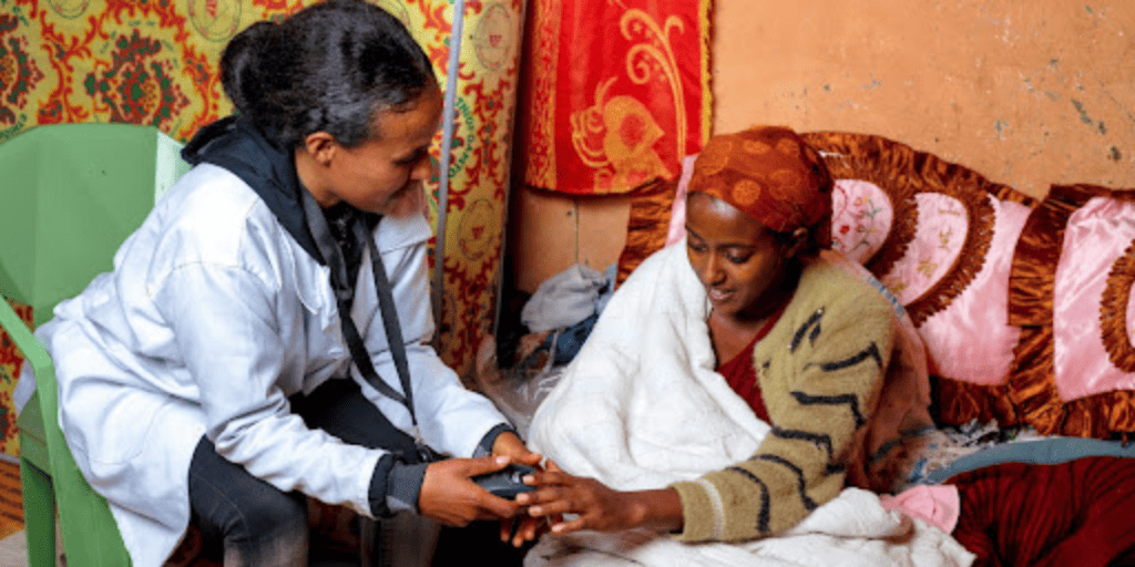 A health worker sits with a patient in Ethiopia.