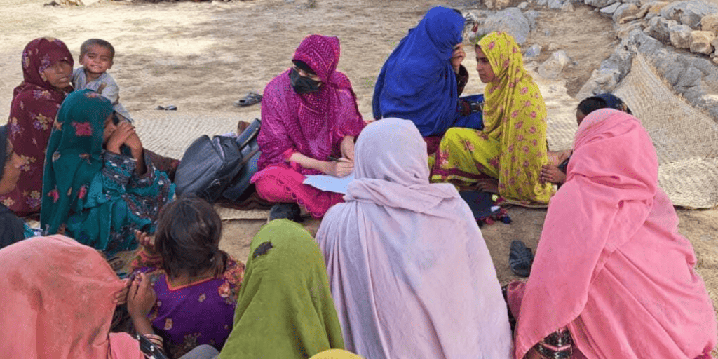 A group of women in Pakistan sit outside together.