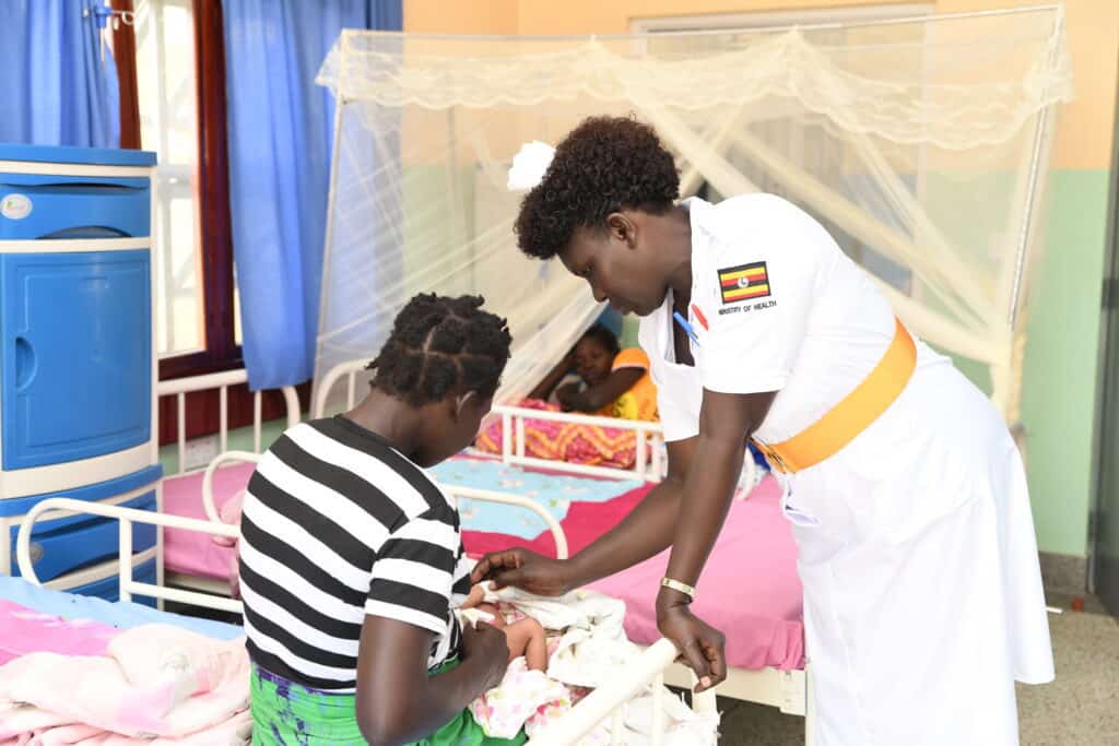 A nurse attends to a mother and child in Uganda