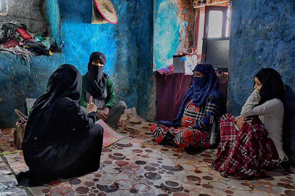 A Yemeni midwife sites with four women conduting an education session on breastfeeding.