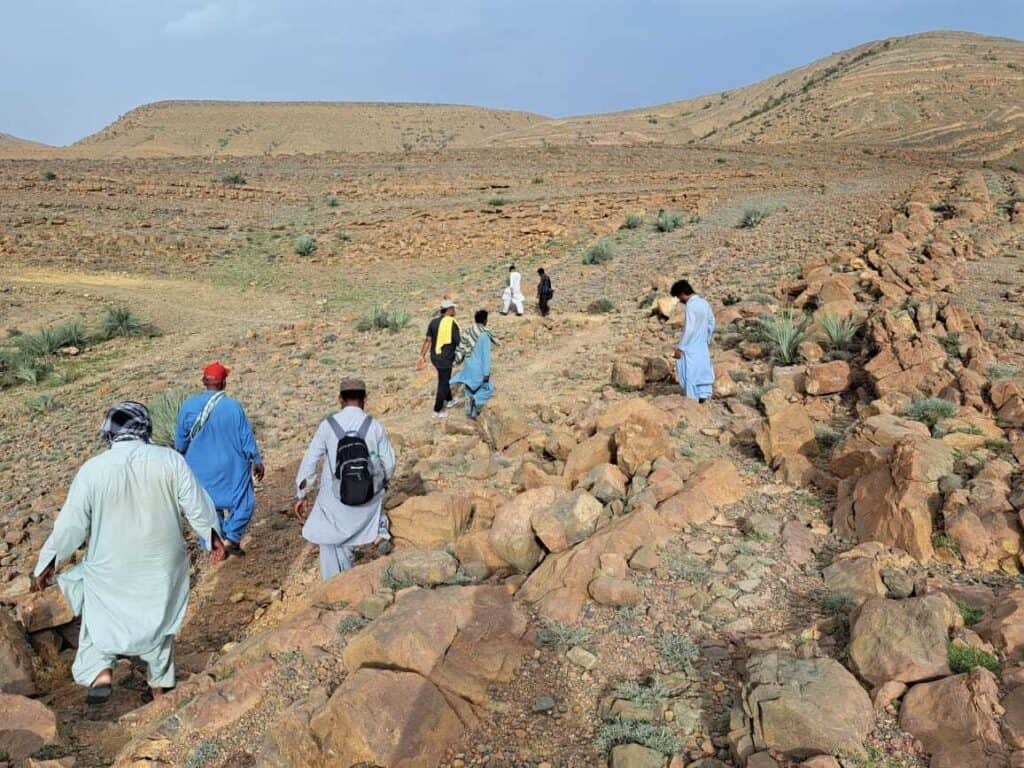 People walk the landscape in Pakistan