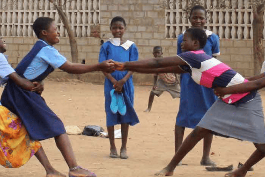Schoolgirls in Africa playing outside together.