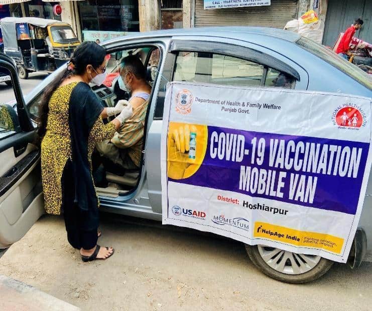 A nurse vaccinates someone in a COVID-19 mobile van.