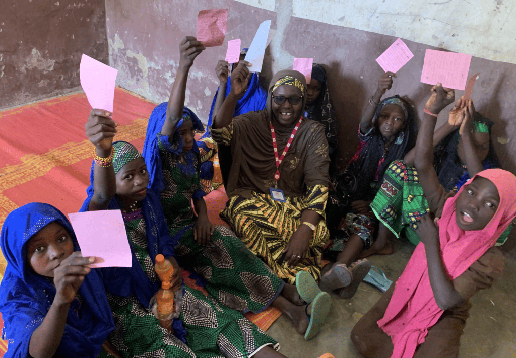 School children in Nigeria hold up their vaccination cards